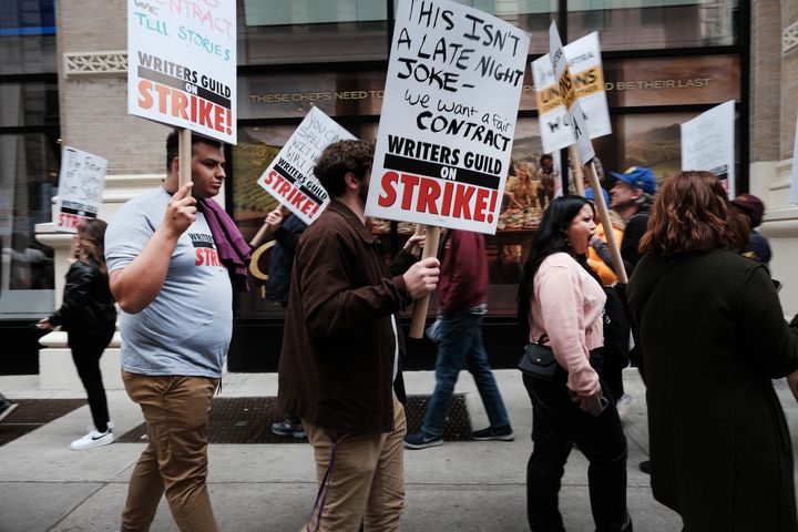 Members of the Writers Guild of America (WGA) East hold signs Wednesday as they walk for the second day on a picket line outside Netflix's New York City office.