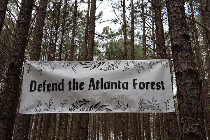 A banner that activists raised above their main campsite is shown in the South River Forest in DeKalb County, Georgia, near the site of a planned police training center on March 9. Activists have been protesting the center's planned construction for more than a year, derisively calling it "Cop City."