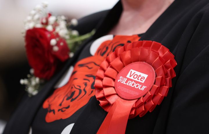 A Labour supporters wears a party rosette at the Stoke-On-Trent election count.