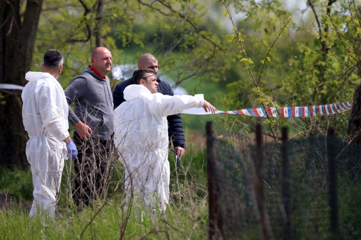 Forensic police inspects the scene around a car in the village of Dubona, some 50 kilometers (30 miles) south of Belgrade, Serbia, on May 5, 2023.