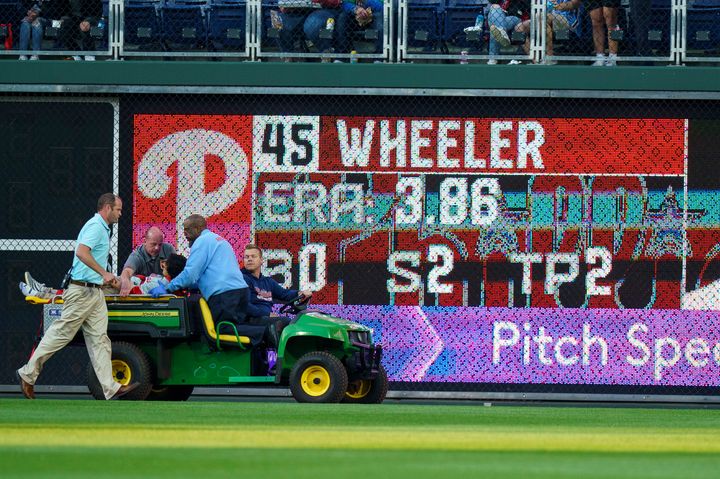 A fan is carted off the field after falling into the Boston Red Sox bullpen on Friday.