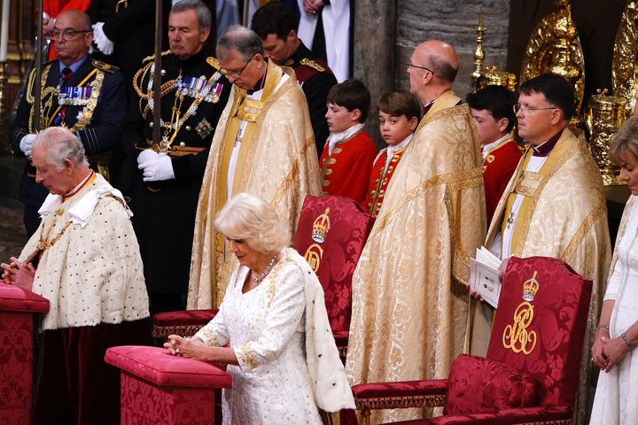 George (center) watches Charles and Camilla during their coronation ceremony.