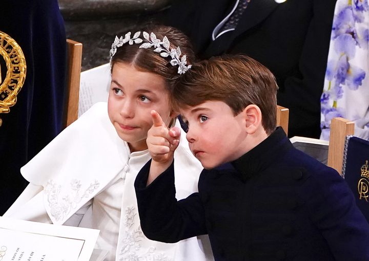 Prince Louis points at something in Westminster Abbey.