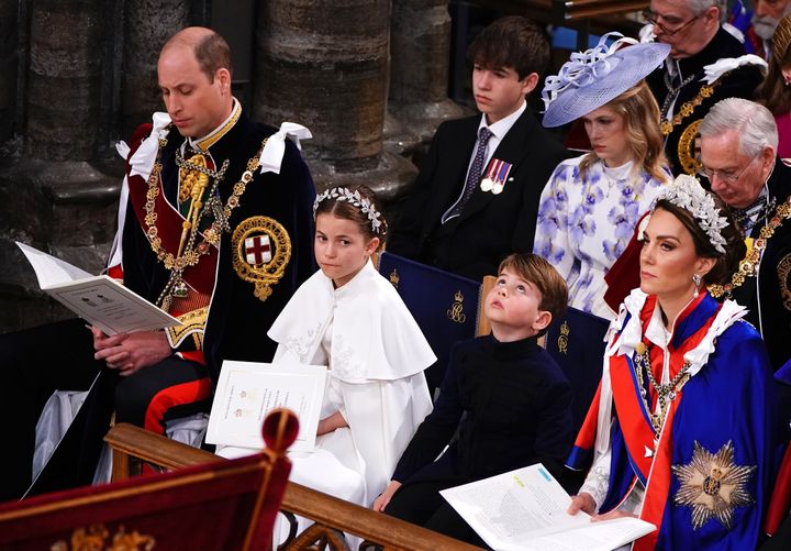 The smallest royal stares at the ceiling while his family members look on.