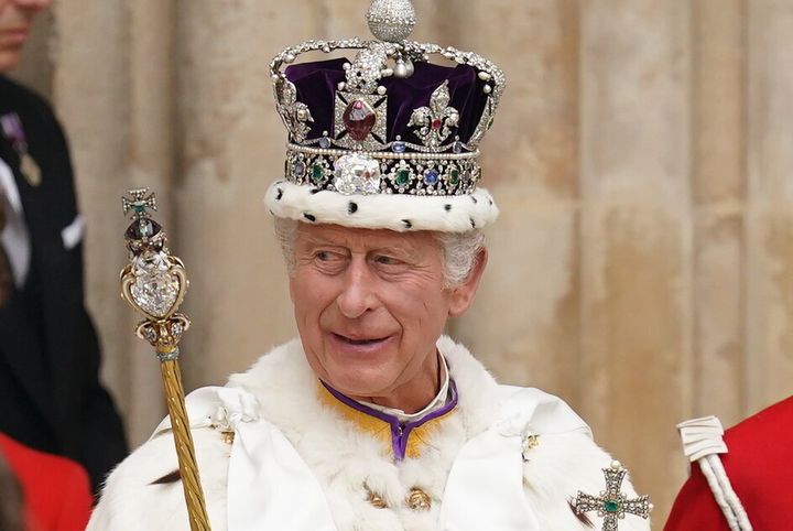 King Charles III, wearing the Imperial State Crown, leaves Westminster Abbey in London following his coronation ceremony. 