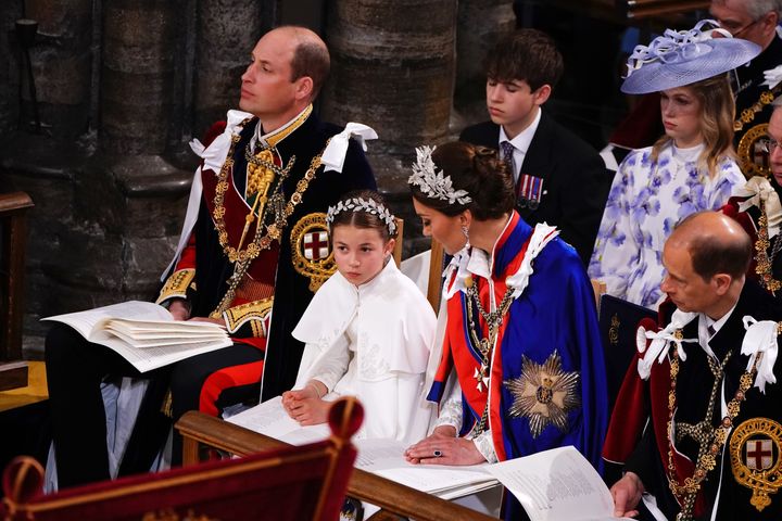 Princess Charlotte sits alone after her brother was whisked away by an aide to enjoy the coronation service behind the scenes.