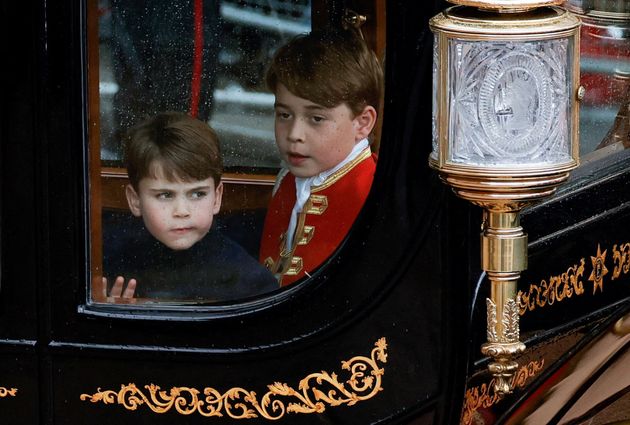 Prince Louis looks serious as he departs the service with older brother George.