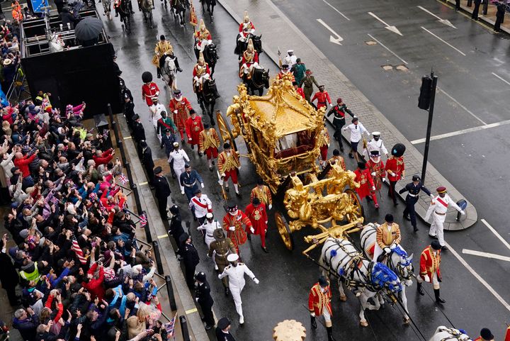 King Charles III and Queen Camilla are carried in the Gold State Coach, pulled by eight Windsor Greys, in the Coronation Procession