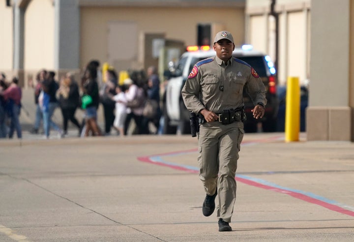 A law enforcement officer runs as people are evacuated from a shopping center where a shooting occurred in Allen, Texas on Saturday. The shooting, the latest eruption of what has been an unprecedented pace of mass killings in the U.S., sent hundreds fleeing in panic.