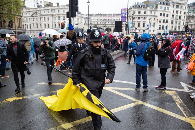 A policeman is seen carrying a banner taken away from protesters during an Anti-monarchist protest during King Charles III's Coronation.