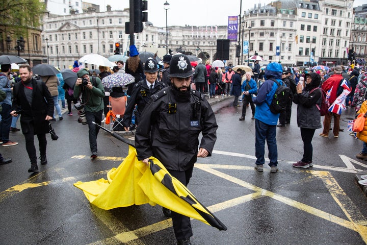 A policeman is seen carrying a banner taken away from protesters during an Anti-monarchist protest during King Charles III's Coronation.