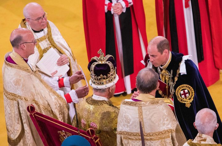 The Prince of Wales kneels before his father, King Charles III, during the king's coronation ceremony inside Westminster Abbey on Saturday.
