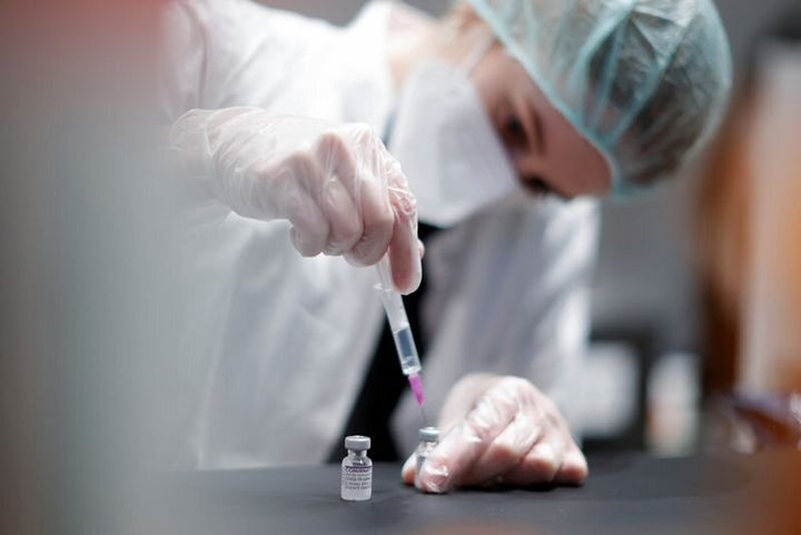 FILE PHOTO: A nurse prepares a shot of "Comirnaty" Pfizer-BioNTech coronavirus disease (COVID-19) vaccine at the vaccination centre in the Humboldt Forum in Berlin, Germany January 19, 2022. REUTERS/Michele Tantussi