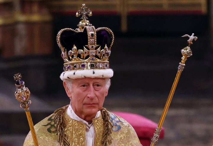 Charles, wearing the St. Edward's Crown and holding the Sovereign's Sceptre with Dove (right) and Sovereign's Sceptre with Cross, is seen during the coronation ceremony.