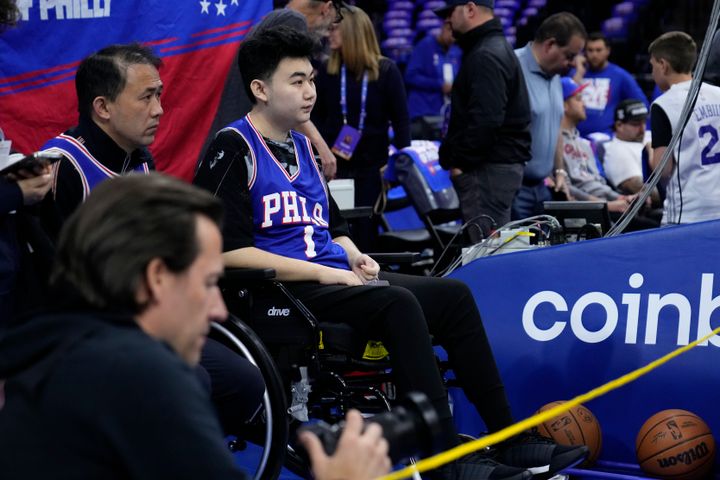 John Hao, second from left, watches warm ups ahead of game four of a second round playoff series between the Philadelphia 76ers and the Boston Celtics on Sunday.
