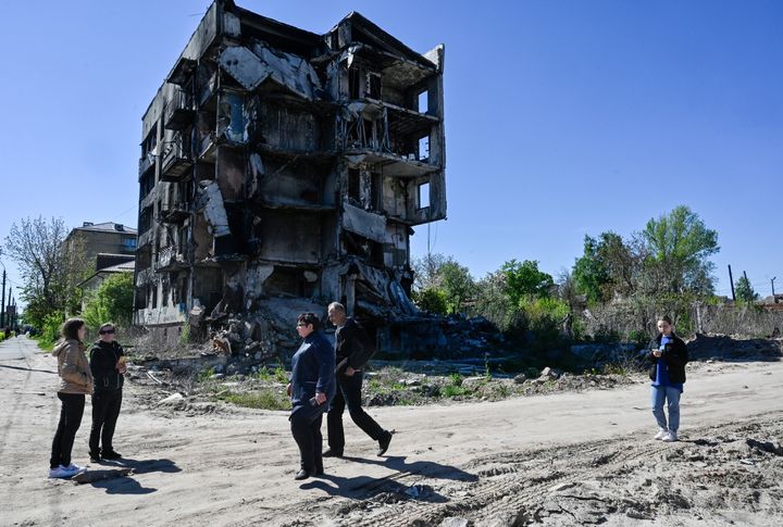 People walk past an apartment building destroyed by the Russian army in the city of Borodyanka, north west Kyiv. 