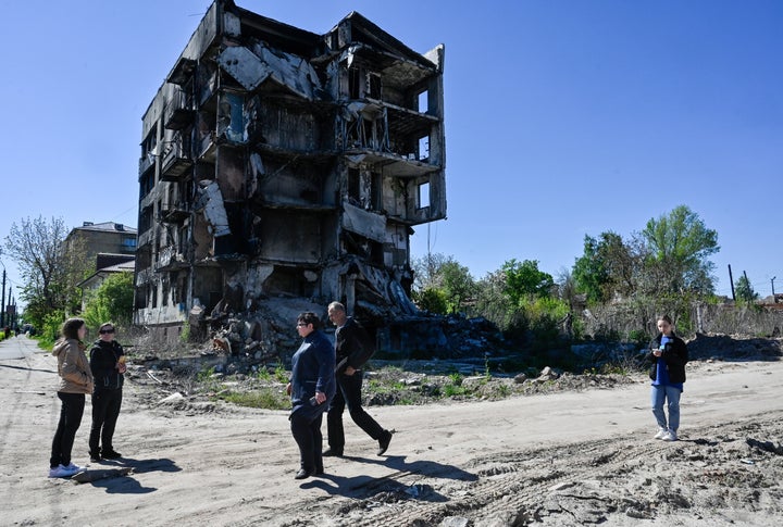 People walk past an apartment building destroyed by the Russian army in the city of Borodyanka, north west Kyiv. 