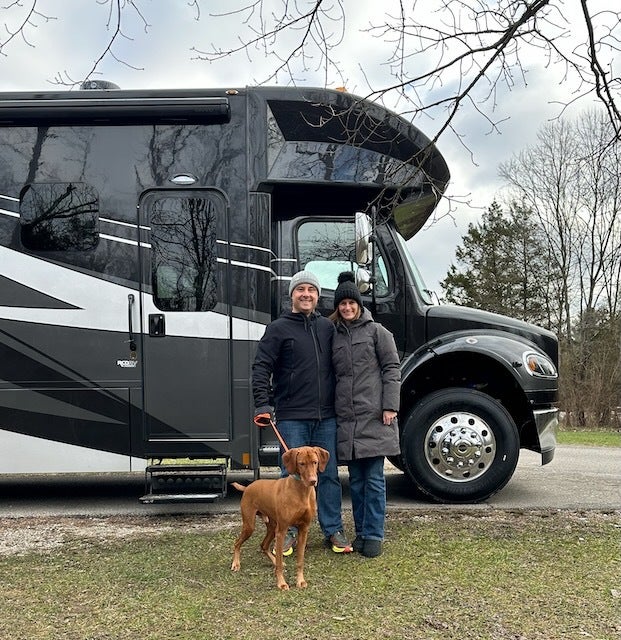 The author and her husband camping in the RV with one of their dogs