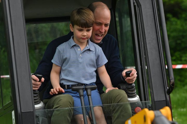 Prince William is helped by Prince Louis as he uses an excavator while taking part in the Big Help Out.