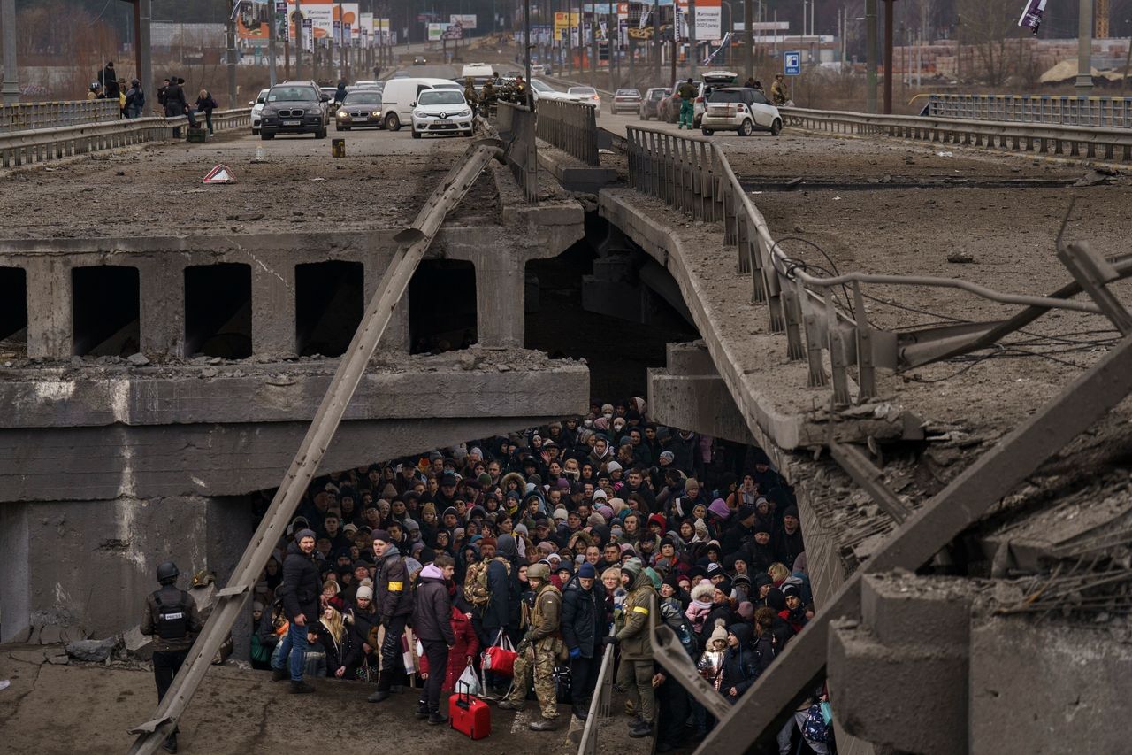 Ουκρανοί συνωστίζονται κάτω από μια κατεστραμμένη γέφυρα καθώς προσπαθούν να φύγουν διασχίζοντας τον ποταμό Irpin στα περίχωρα του Κιέβου, Ουκρανία, 5 Μαρτίου 2022. Η εικόνα ήταν μέρος μιας σειράς εικόνων από φωτογράφους του Associated Press που τιμήθηκαν με το βραβείο Πούλιτζερ 2023 για Φωτογραφία έκτακτων ειδήσεων. (AP Photo/Emilio Morenatti)