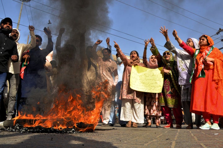 Supporters of Pakistan's former Prime Minister Imran Khan chant slogans next to burning tires during a protest to condemn the arrest of their leader, in Hyderabad, Pakistan, on May 9, 2023.
