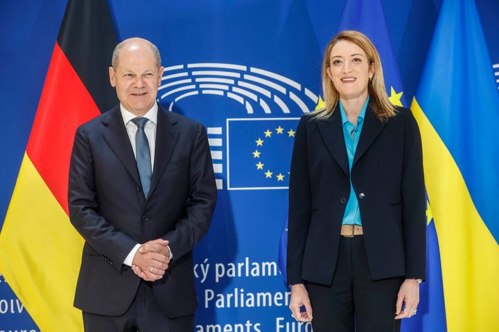 German Chancellor Olaf Scholz stands with president of the European Parliament Roberta Metsola in front of German and European flags Tuesday, may 9, 2023 in Strasbourg, eastern France. (AP Photo/Jean-Francois Badias)