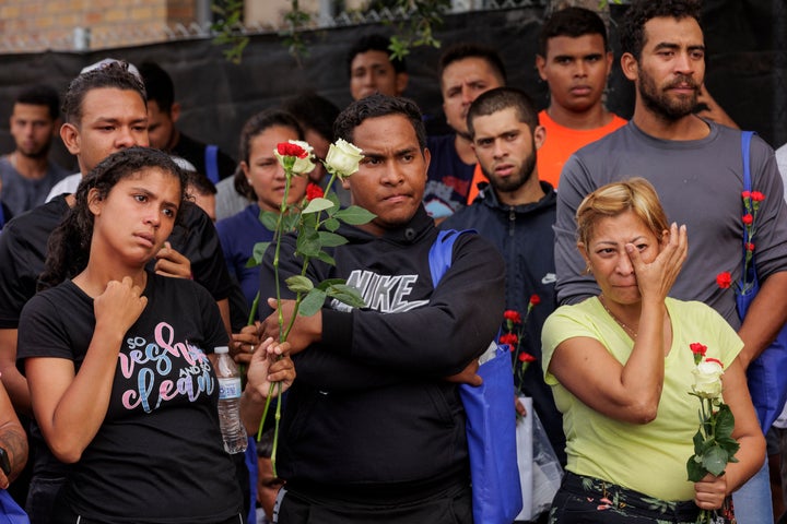 People hold flowers and listen to speakers during a vigil for the eight that were killed and several others that were injured the day before while waiting at a bus stop, in Brownsville, Texas, on May 8, 2023. 