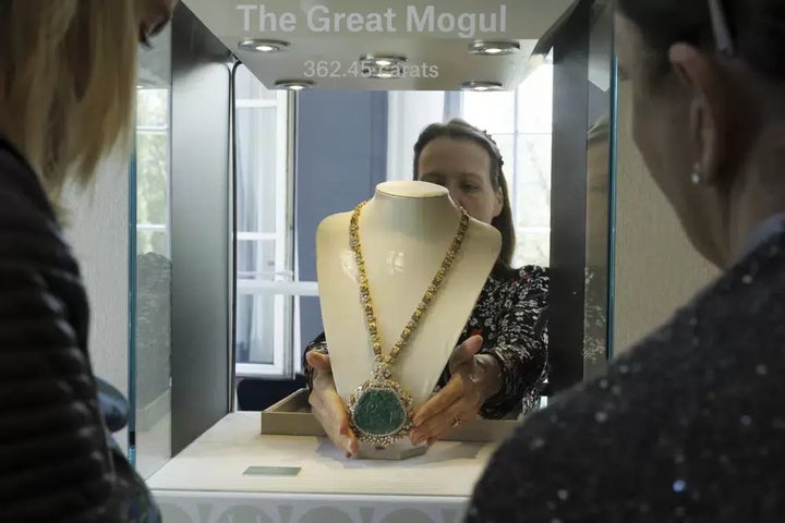 An employee of Christie's displays the Great Mogul Emerald and Diamond Necklace by Harry Winston during the preview of "The World of Heidi Horten."