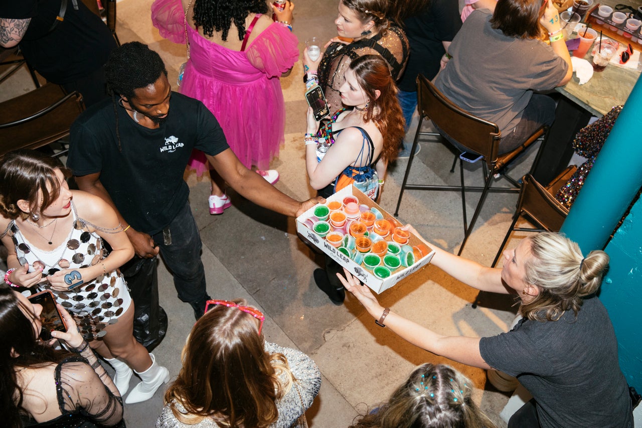 Wild Leap employees pass Jello shots toward the bar.