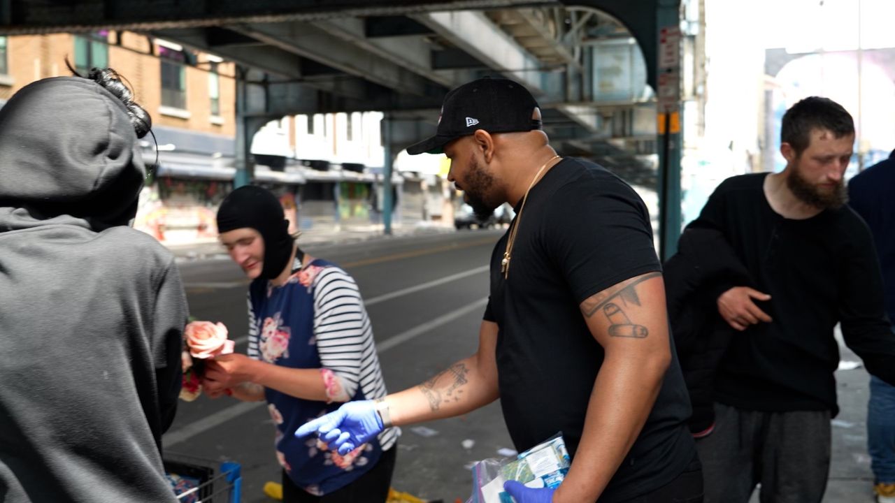Pastor Carl Day Sr., second from right, hands out care packages in Philadelphia's Kensington neighborhood.
