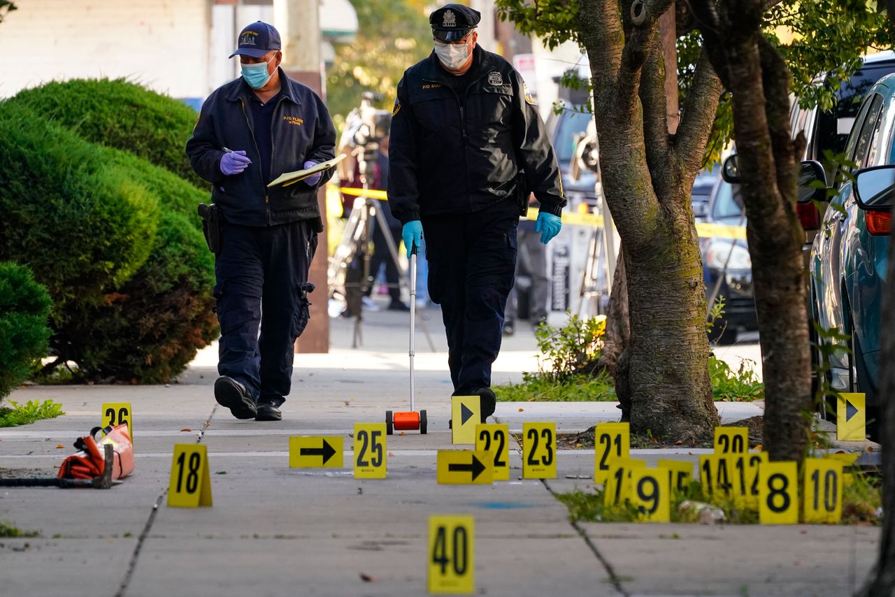 Investigators work the scene where multiple people were shot when a SWAT team attempted to serve a homicide warrant in Philadelphia on Oct. 12, 2022. 