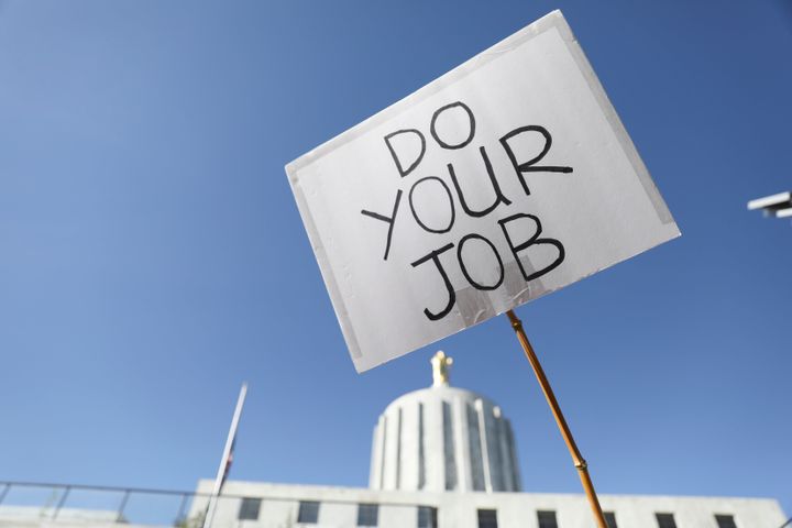 A participant holds up a sign during a rally calling for an end to the Senate Republican strike at the Oregon State Capitol in Salem, Oregon on Thursday, May 11, 2023. (AP Photo/Amanda Loman)
