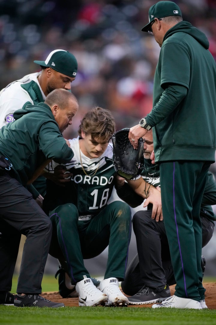 Trainers help up Feltner after he was struck during the second inning of the team's baseball game.