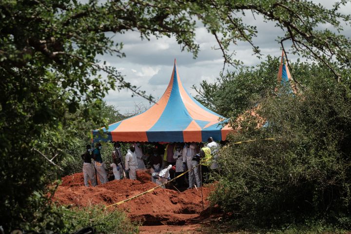 Workers take shelter while digging the ground to exume bodies from the mass-grave site in Shakahola on April 25. A cult was believed to be practising mass starvation.