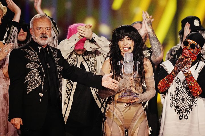 Sweden entrant Loreen is presented with the trophy by Kalush Orchestra and Graham Norton after winning the Eurovision Song Contest 