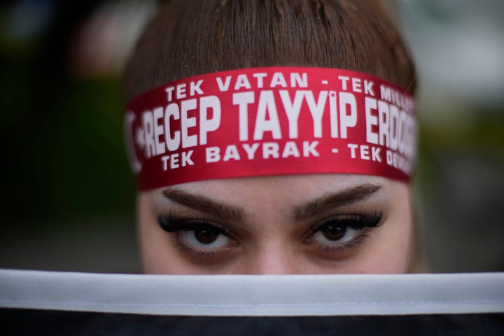 A supporter of President Recep Tayyip Erdogan stands outside the headquarters of AK Party in Istanbul, Turkey, Sunday, May 14, 2023.