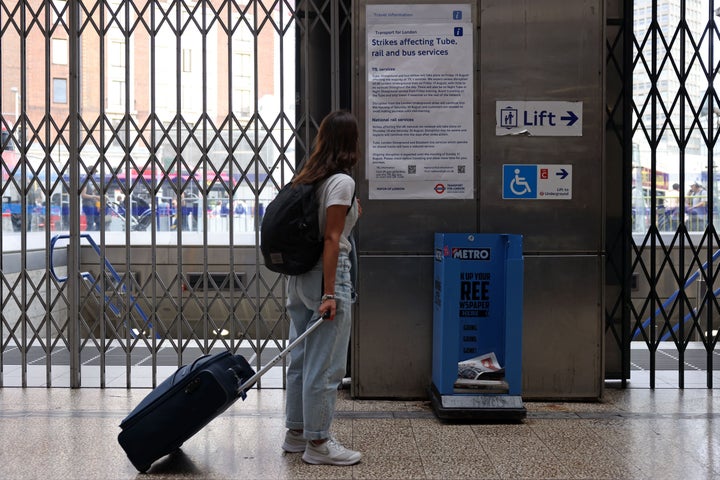 A traveler studies the information sheet displayed outside a London Underground station as public transport workers hold strikes over pay and conditions.