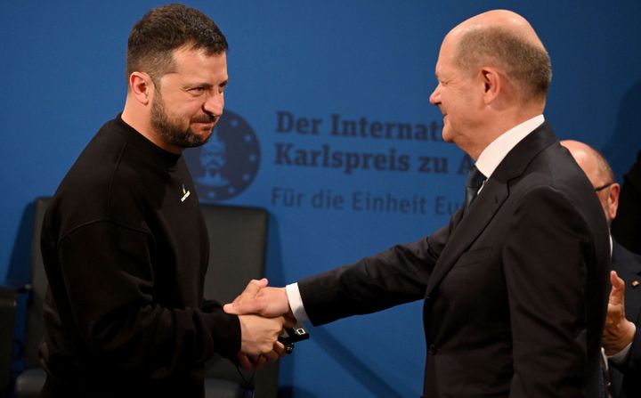 Ukrainian President Volodymyr Zelenskyy, left, and German Chancellor Olaf Scholz, right, shake hands during the award ceremony of the Charlemagne Prize in Aachen, Germany, on May 14, 2023.