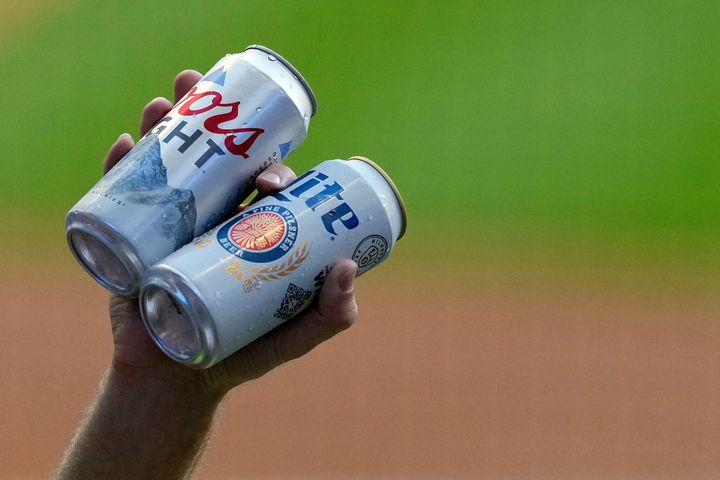 A beer vendor holds cans of Coors Light and Miller Lite during a baseball game on June 24, 2022, in Milwaukee.