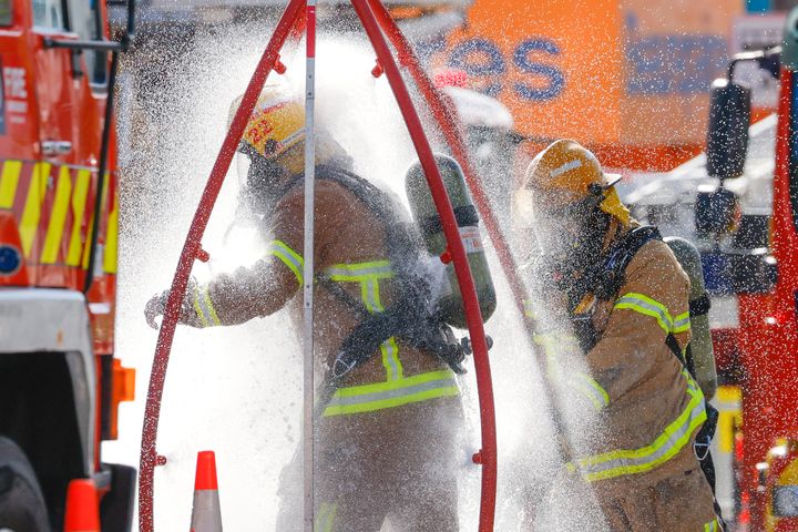 Firefighters rinse off after a fire at Loafers Lodge in Wellington. 