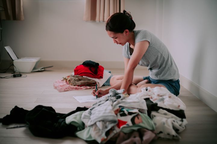 A woman is putting her clothes to be donated.