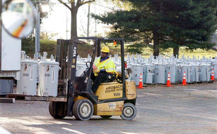 In this Thursday, Nov. 1, 2012, file photograph, PSE&G employee Percy Thompson III unloads new electrical transformers as New Jersey's biggest utility rebuilds its grid after Superstorm Sandy.