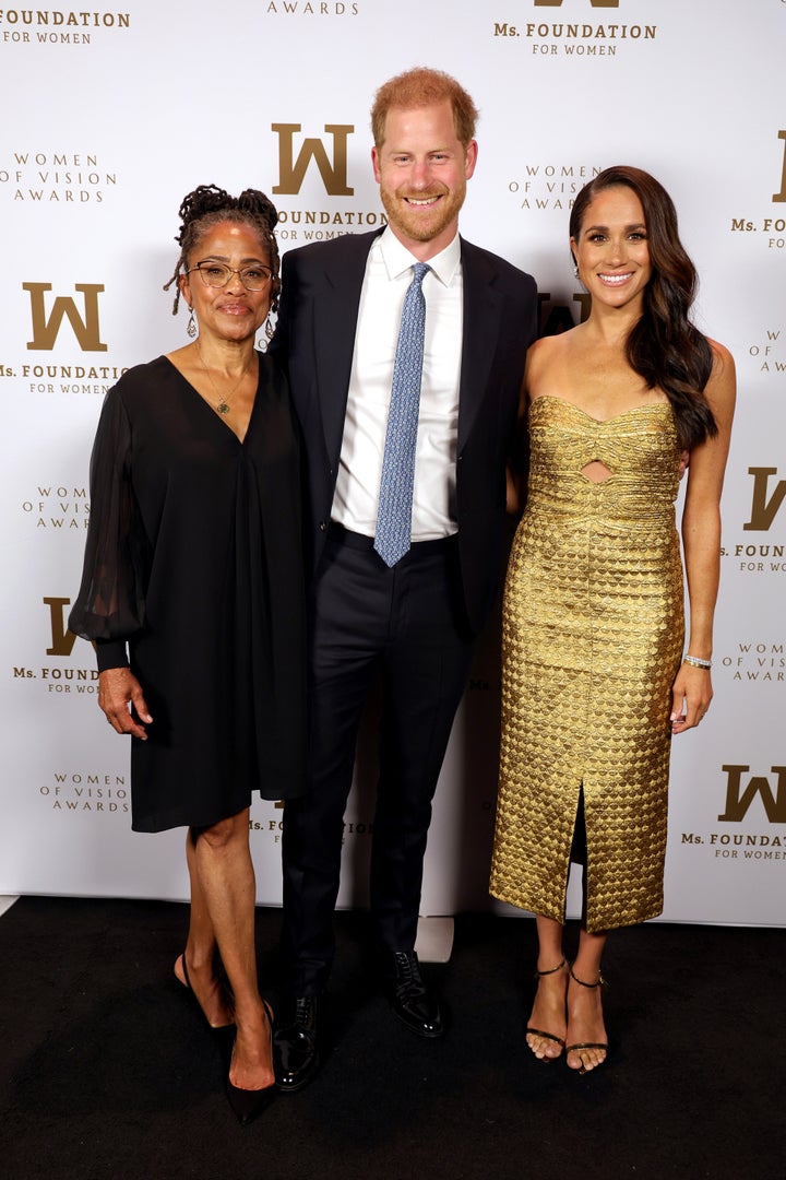 Doria Ragland, Prince Harry and Meghan pictured together on Tuesday night. The Duchess of Sussex wore a gold dress by Johanna Ortiz, and earrings by J. Crew. 