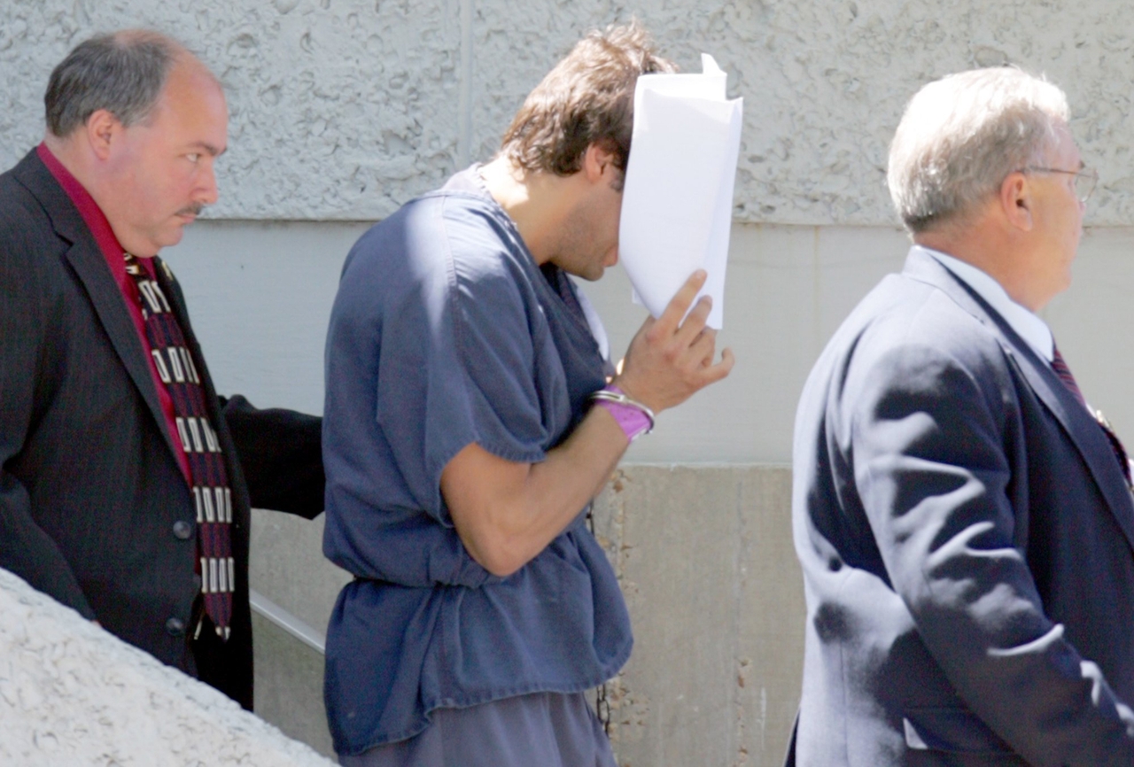 Francis uses papers to block his face as he leaves the federal courthouse in Panama City on April 12, 2007.
