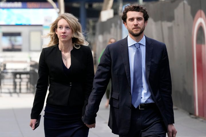 Former Theranos CEO Elizabeth Holmes, left, and her partner, Billy Evans, leave federal court in San Jose, on March 17, 2023. 