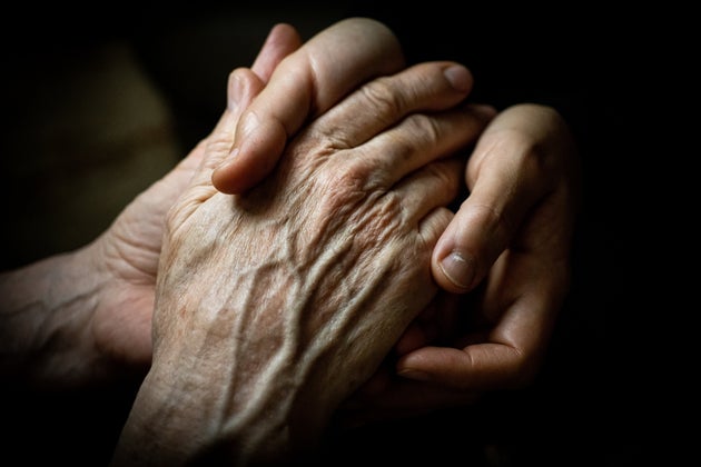 Young woman holding elderly hands