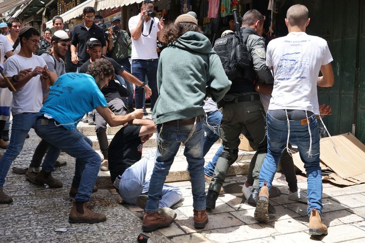 Participants of an Israeli annual far-right, flag-waving rally, beat a Palestinian man during the event in the Old City of Jerusalem, on May 18, 2023. Jerusalem police and residents were bracing for extremist ministers and their supporters to rally today in an annual flag-waving march commemorating Israel's capture of the Old City. Following the 1967 Six-Day War, Israel annexed east Jerusalem and its Old City in a move never recognized by the international community.