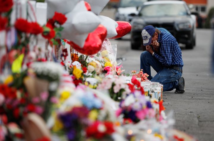 A man cries beside a cross at a makeshift memorial near the scene of a mass shooting at a Walmart in El Paso, Texas, in 2019. Abbott blamed mental illness and said he didn’t think “red flag” laws could have stopped the gunman.