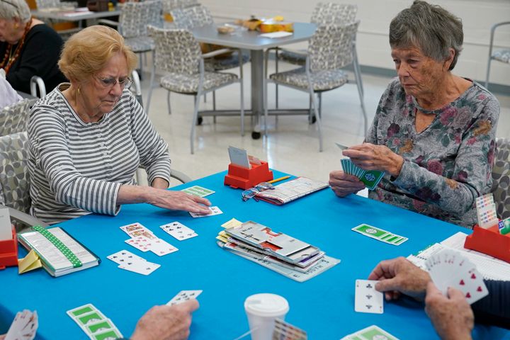 Doris Askin, 84, of Mount Vernon, Virginia (left), and Barbara Steingaszner, 83, of Alexandria, Virginia, play bridge at a seniors' center in Alexandria in October 2022.