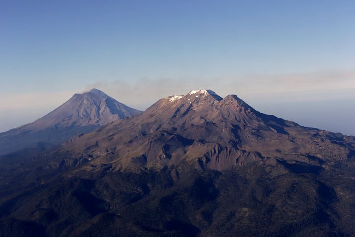 FILE - In this July 23, 2013 file photo, smoke rising from the crater of the Popocatepetl volcano is carried away by wind, next to dormant Iztaccihuatl volcano.